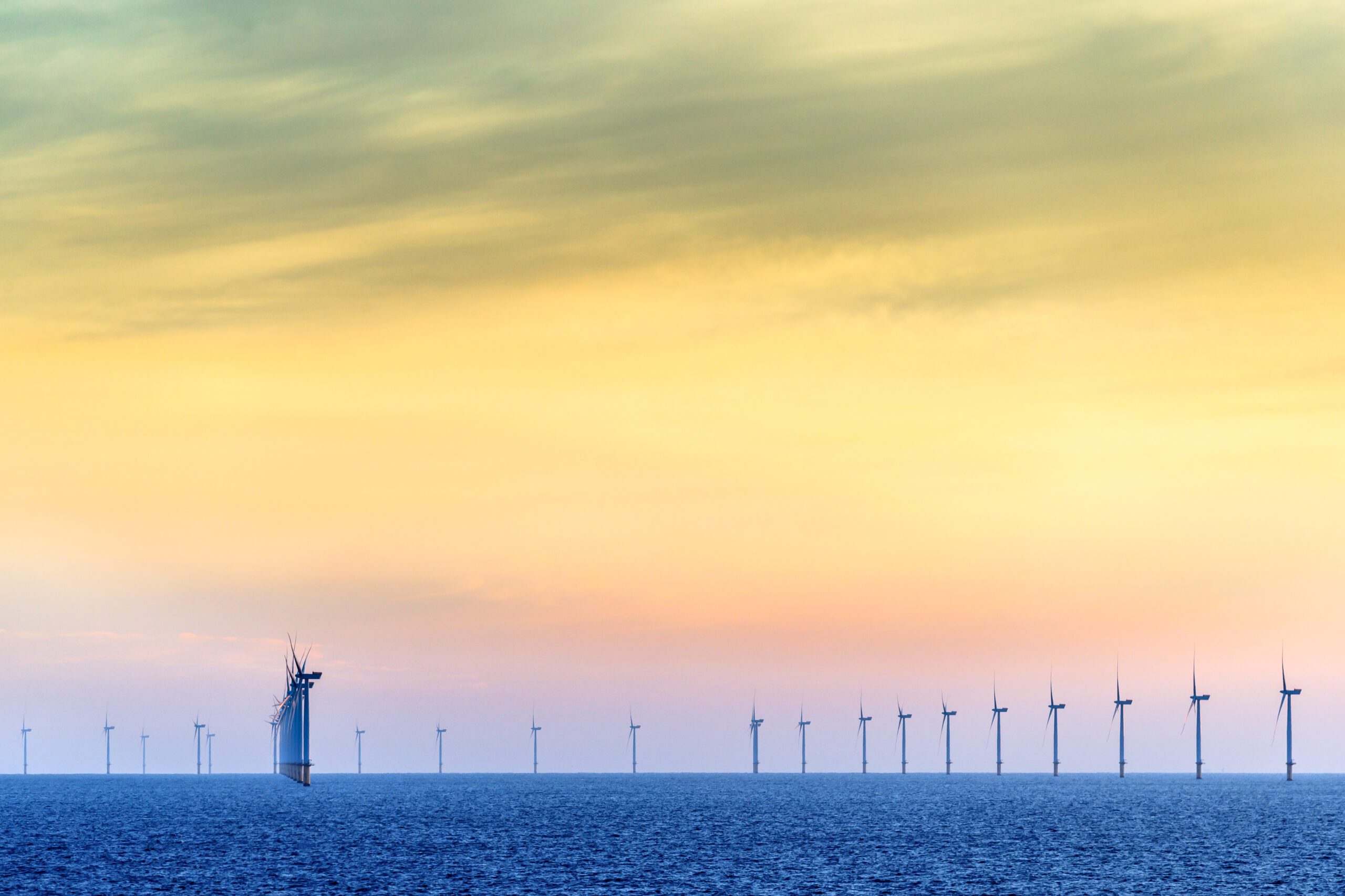 HORNSEA OFFSHORE WIND FARM, UK - 2016 JULY 15. Wind farm with the sun setting in the background.