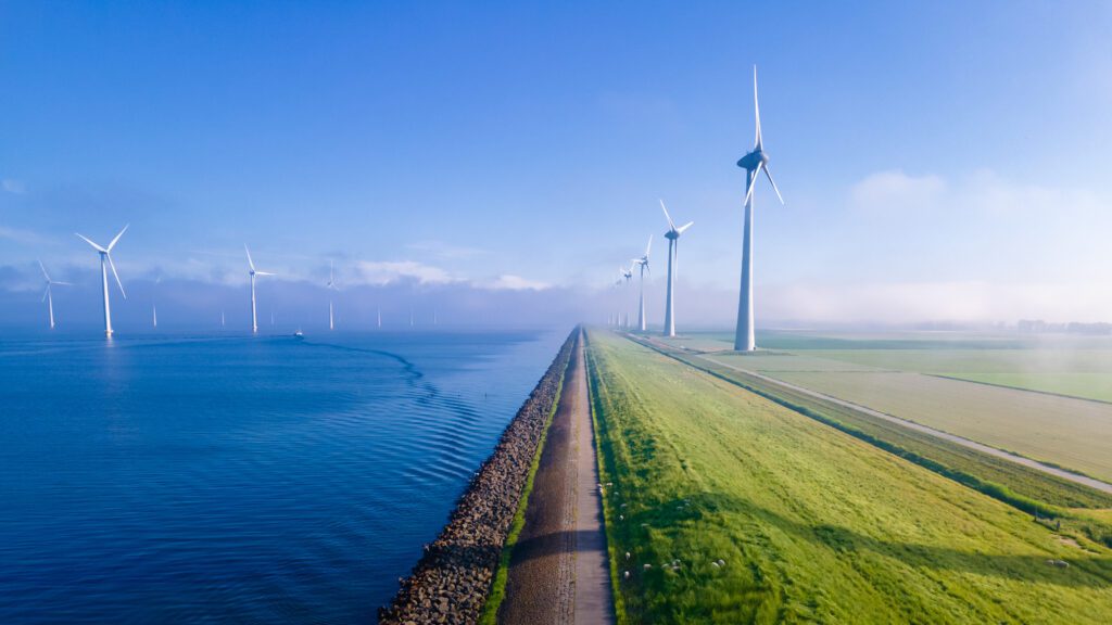 offshore windmill park with clouds and a blue sky, windmill park in the ocean drone aerial view with wind turbine Flevoland Netherlands