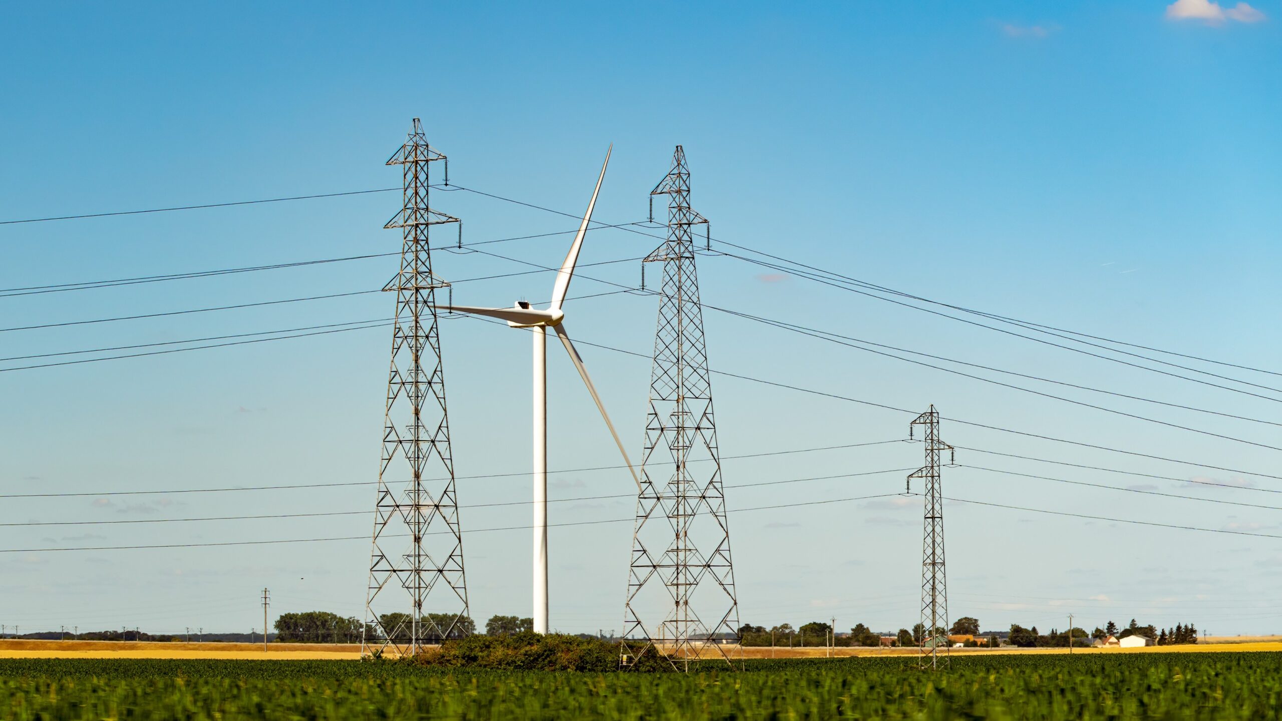 uk electricity transmission towers and a wind turbine representing ofgem's grid reforms