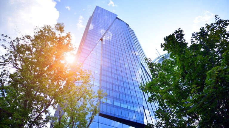 Sustainable glass office building with trees representing net zero