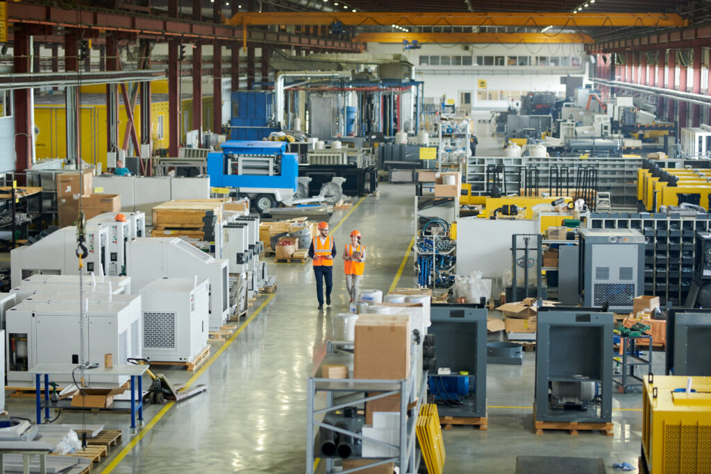 Busy manufacturing plant uk with two workers walking through centre
