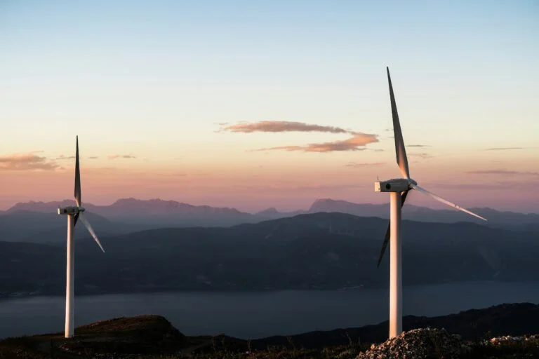 wind turbines at dusk with mountains in the background representing energy deadlines