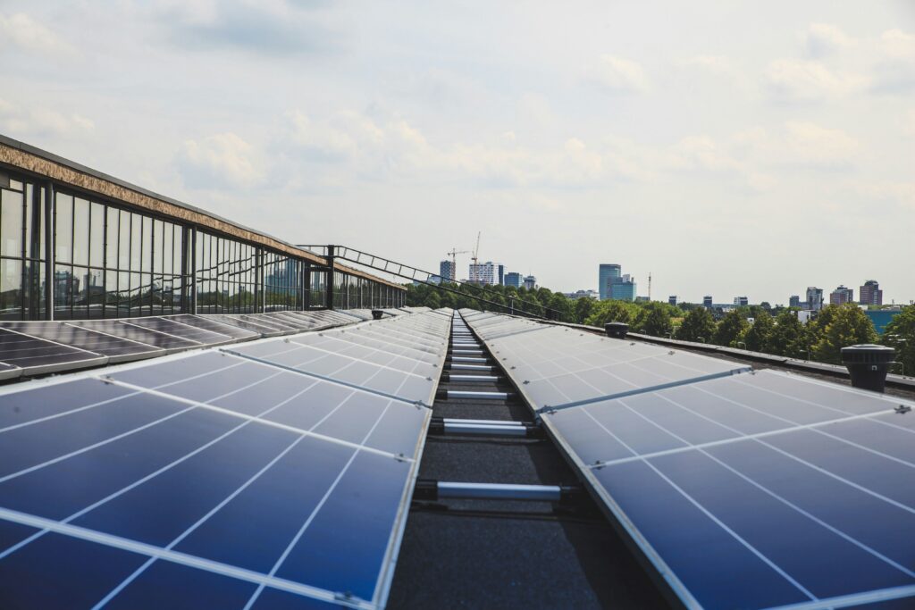 solar panels on roof of building with cityscape and trees in the background representing renewables