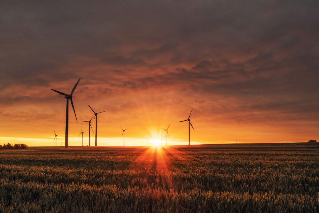 windmill on grass with sunset - renewable energy generation